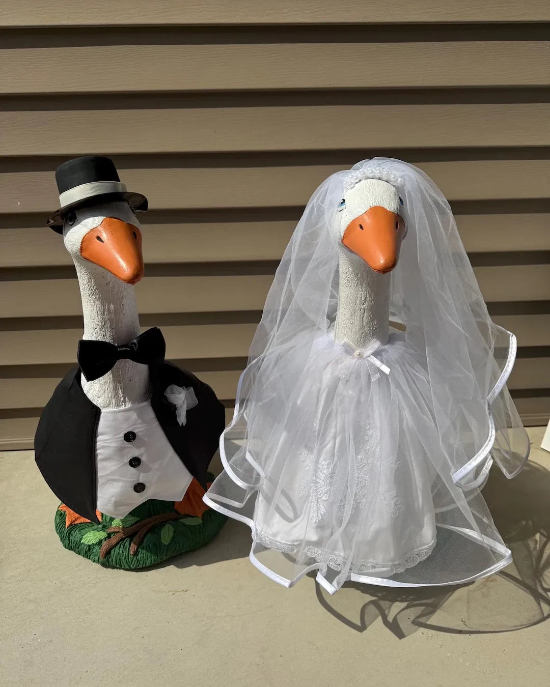 Two porch geese dressed as a bride and groom